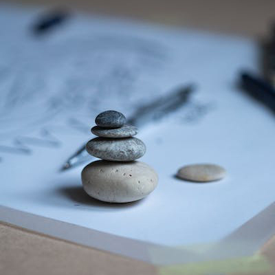A creative difference. Pen and stacked rocks on a notepad